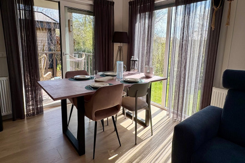 Coin repas au Chalet près de la plage de Sint Maartenszee, Pays-Bas, avec table et vue sur le jardin.