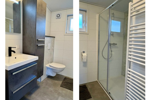 Salle de bain moderne au chalet près de Sint Maartenszee Beach avec douche vitrée, lavabo et meuble de rangement.