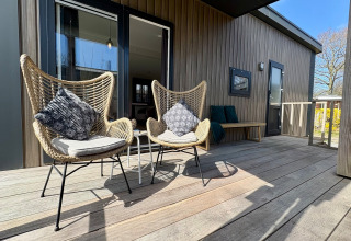 Terrasse ensoleillée au chalet près de Sint Maartenszee Beach, Pays-Bas, avec chaises confortables.