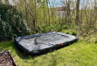 Trampoline rectangulaire enterré dans un jardin au Chalet près de la plage Sint Maartenszee, aux Pays-Bas.