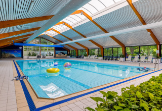 Overdekt zwembad met opblaasbare speelgoed in een chalet vlakbij Sint Maartenszee strand, Nederland.