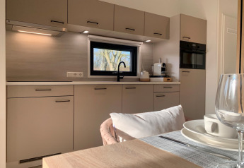 Cucina moderna del Chalet a Sint Maartenszee, Paesi Bassi, con tavolo da pranzo e finestra panoramica.