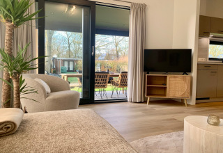 Helles Wohnzimmer im Strandhaus Chalet in Sint Maartenszee, Niederlande, mit Blick auf Terrasse.