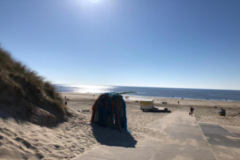 Vista de la playa desde el chalet en Sint Maartenszee cerca de Sandy Beach, Países Bajos, con sol.