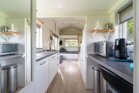 Interior moderno y luminoso de una tiny house con cocina y sala de estar en los Países Bajos.
