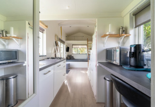 Interior moderno y luminoso de una tiny house con cocina y sala de estar en los Países Bajos.
