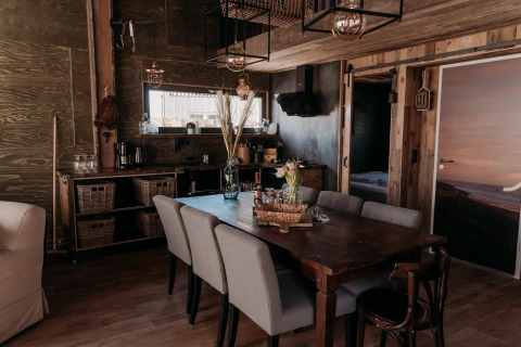 Accogliente sala da pranzo nella lodge Juttershut Duynpark Callantsoog nei Paesi Bassi con arredi rustici e moderni.