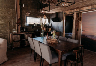 Accogliente sala da pranzo nella lodge Juttershut Duynpark Callantsoog nei Paesi Bassi con arredi rustici e moderni.