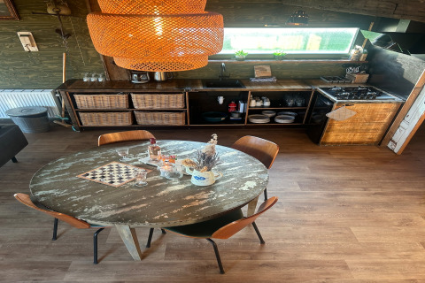 Cucina rustica con tavolo rotondo e sedie al Juttershut Duynpark, Callantsoog, Paesi Bassi.