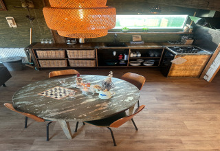 Cucina rustica con tavolo rotondo e sedie al Juttershut Duynpark, Callantsoog, Paesi Bassi.