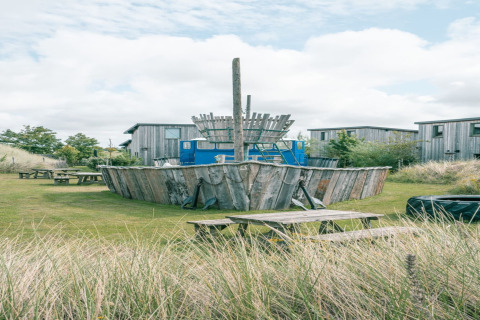 Area giochi all'aperto con nave di legno e panche da picnic a Juttershut Duynpark, Callantsoog, Paesi Bassi.