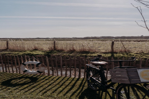 Vista dal Juttershut Duynpark Callantsoog, Paesi Bassi, con una bicicletta e un salvagente vicino alla staccionata.
