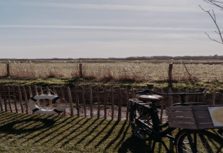 Vista dal Juttershut Duynpark Callantsoog, Paesi Bassi, con una bicicletta e un salvagente vicino alla staccionata.