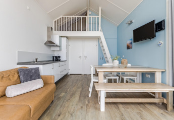 Modern strandhuisinterieur in Julianadorp, Nederland, met vide, open keuken en eetgedeelte.