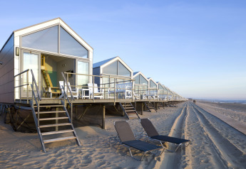 Rij moderne strandhuisjes bij Resort Beach Houses Julianadorp 1, direct aan het zandstrand in Nederland.
