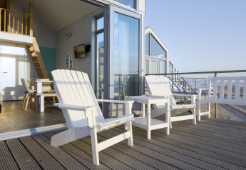 Strandhuis met terras, twee witte stoelen en zeezicht, ontspanning in Julianadorp, Nederland.