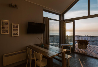 Modern strandhuis interieur met uitzicht op zonsondergang bij Resort Beach Houses Julianadorp in Nederland.