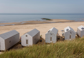 Strandhuisjes op het zand met zeezicht bij Resort Beach Houses Julianadorp 1 aan de Nederlandse kust.