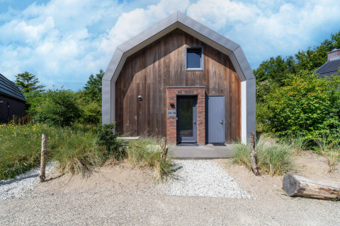 Modernes Ferienhaus „Waterland für sechs Personen“ in den Niederlanden mit Holzfassade und Sandweg.