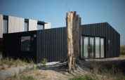 Modernes Strandhaus Sea Lodges Zandvoort 9 in den Niederlanden, schwarze Holzverkleidung und Glas.