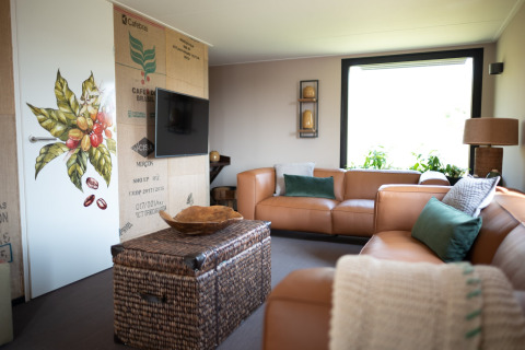 Modern living room at Sea Lodges Zandvoort 11, Netherlands, with leather sofas and large window.