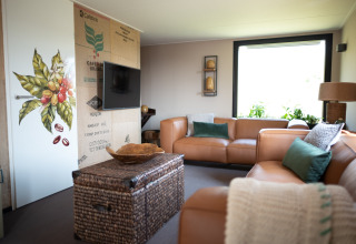 Modern living room at Sea Lodges Zandvoort 11, Netherlands, with leather sofas and large window.