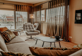 Bright, modern living room aboard Waterpark de Meerparel 5 houseboat in the Netherlands with stylish decor.