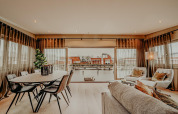 Modern living room in houseboat Waterpark «de Meerparel 5», Netherlands, overlooking water and houses.