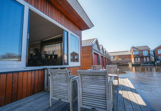 Husflåde ved Waterpark de Meerparel 5, med åbent vindue og stole på terrassen, Holland.
