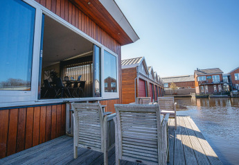 Houseboat at Waterpark de Meerparel 5 in the Netherlands, open window, deck with chairs by the water.