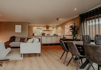 Modern living and dining area on houseboat Waterpark de Meerparel 5, stylishly furnished in the Netherlands.