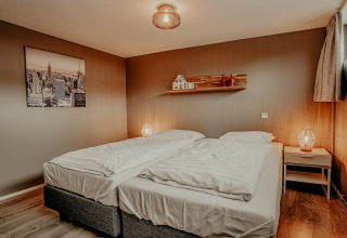 Dormitorio acogedor con dos camas individuales, lámparas y decoración moderna en la casa flotante Meerparel 5.