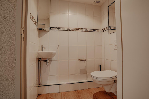Moderne badkamer op woonboot Waterpark de Meerparel 5 in Nederland, met hangtoilet en wastafeltje.