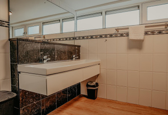 Modern bathroom on houseboat Waterpark de Meerparel 5 in the Netherlands with double sink and large windows.