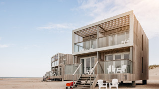 Moderne strandhuse med store altaner og havemøbler på stranden ved Resort Hoek van Holland.