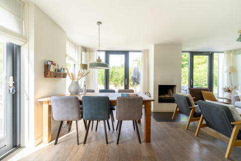 Casa de vacaciones luminosa en Países Bajos con comedor, sala de estar y grandes ventanas al jardín.