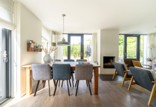 Casa de vacaciones luminosa en Países Bajos con comedor, sala de estar y grandes ventanas al jardín.