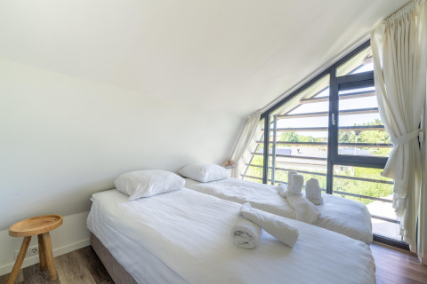 Lichte slaapkamer in Holiday home Waterland for six Person in Nederland met grote ramen en twee bedden.