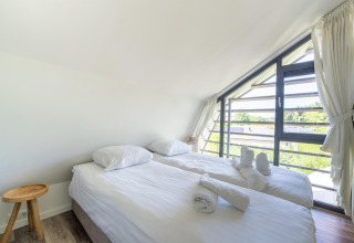 Camera luminosa presso Holiday home Waterland for six Person in Olanda, con grandi finestre e letti gemelli.