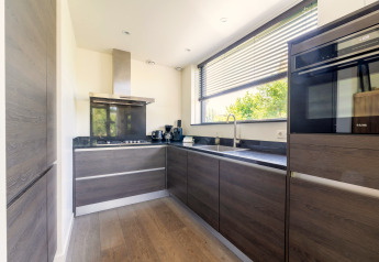 Moderne køkkenindretning i Holiday home «Waterland for six Person» med store vinduer i Holland.
