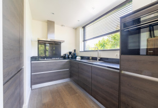 Cocina moderna en la casa «Waterland for six Person» con ventana grande en los Países Bajos.
