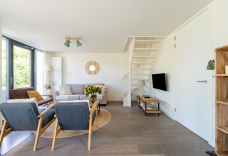 Luminoso soggiorno moderno nella casa vacanze 'Waterland for six Person' nei Paesi Bassi, arredato con stile.