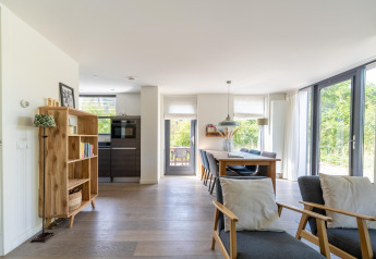 Bright living and dining area of Holiday home Waterland for six Person in the Netherlands, with large windows.