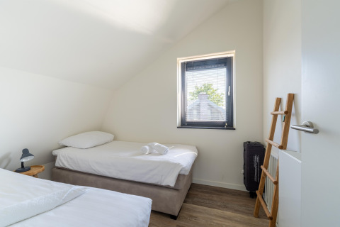 Camera luminosa e minimalista nella Holiday home Waterland for six Person, Paesi Bassi, con due letti singoli.