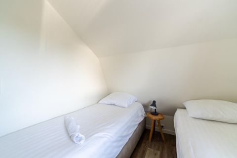 Heldere slaapkamer in het vakantiehuis 'Waterland for six Person' in Nederland, met twee eenpersoonsbedden.