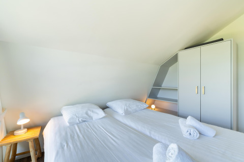 Dormitorio luminoso en Holiday home Waterland for six Person en los Países Bajos con dos camas individuales.