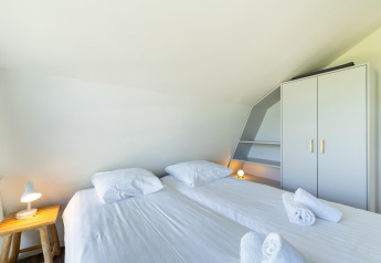 Dormitorio luminoso en Holiday home Waterland for six Person en los Países Bajos con dos camas individuales.