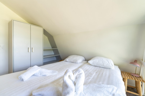 Schlafzimmer im Ferienhaus Waterland für sechs Personen in den Niederlanden mit Doppelbett und Schrank.