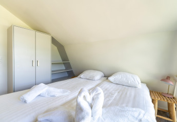 Chambre de la maison de vacances Waterland pour six personnes aux Pays-Bas avec lit double et armoire.