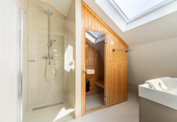 Moderne bruser og sauna i et lyst badeværelse med ovenlys i feriehuset Waterland for seks personer i Holland.